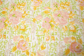 A sequin embroidery fabric on white mesh with yellow-pink florals over green geometric patterns.