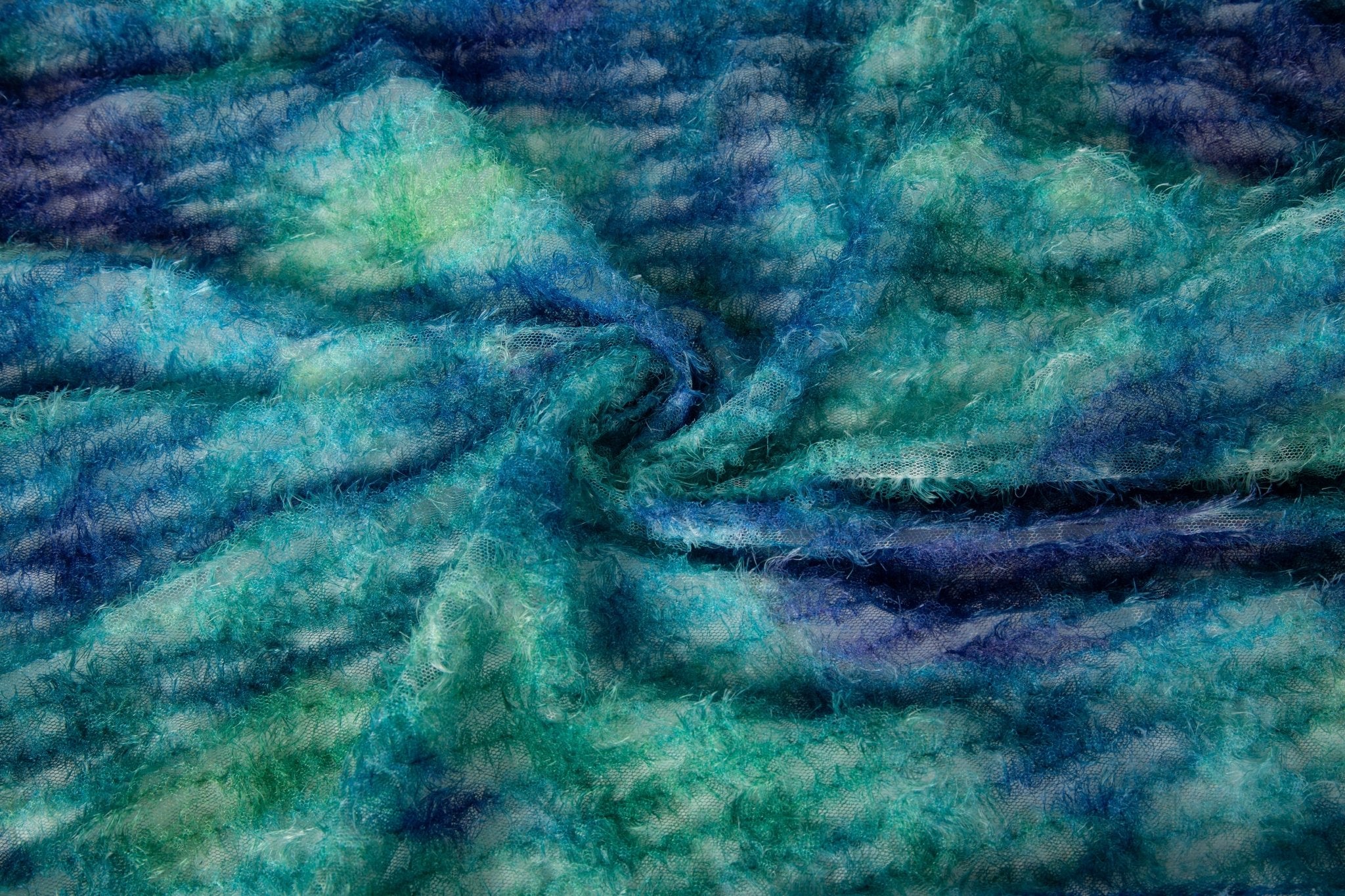 A 3D textured abstract embroidery fabric with a plush feel, in a palette of blue and green