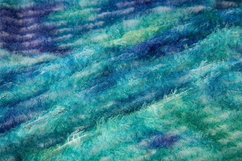 A 3D textured abstract embroidery fabric with a plush feel, in a palette of blue and green