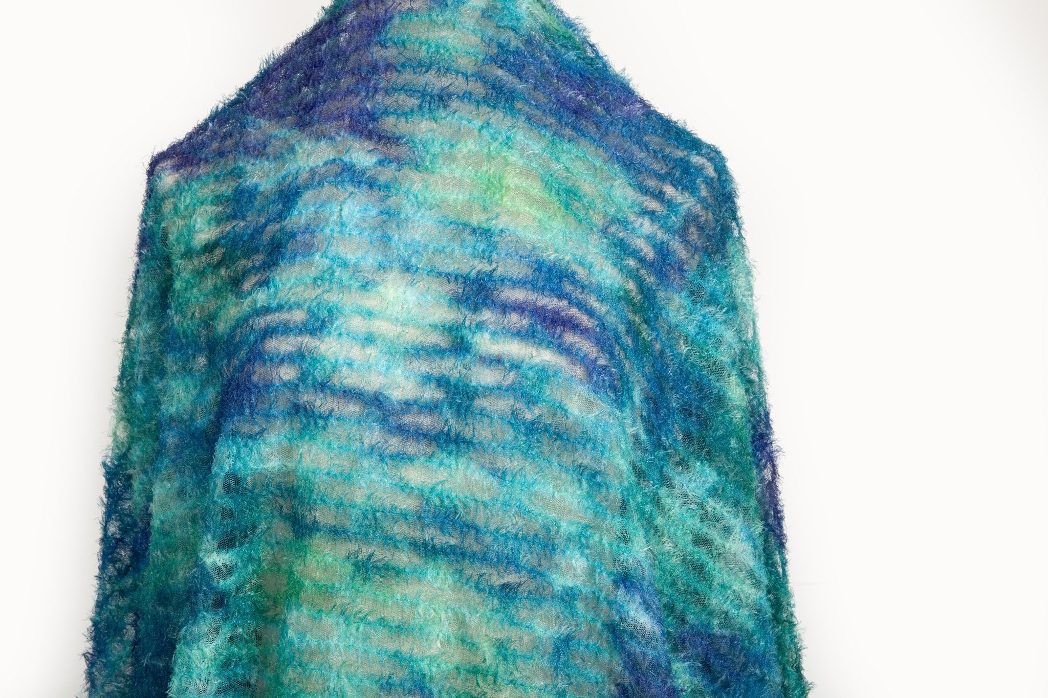 A 3D textured abstract embroidery fabric with a plush feel, in a palette of blue and green