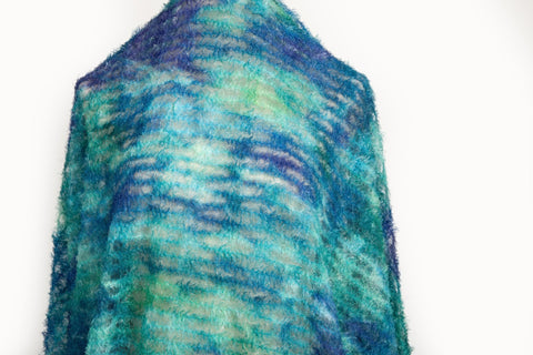 A 3D textured abstract embroidery fabric with a plush feel, in a palette of blue and green