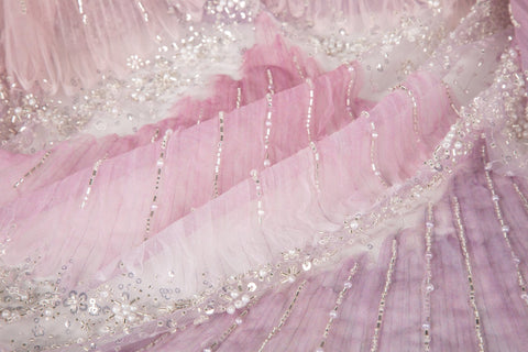 A 3D embroidery fabric with ribbon scallop motifs in a pink and lilac gradient.