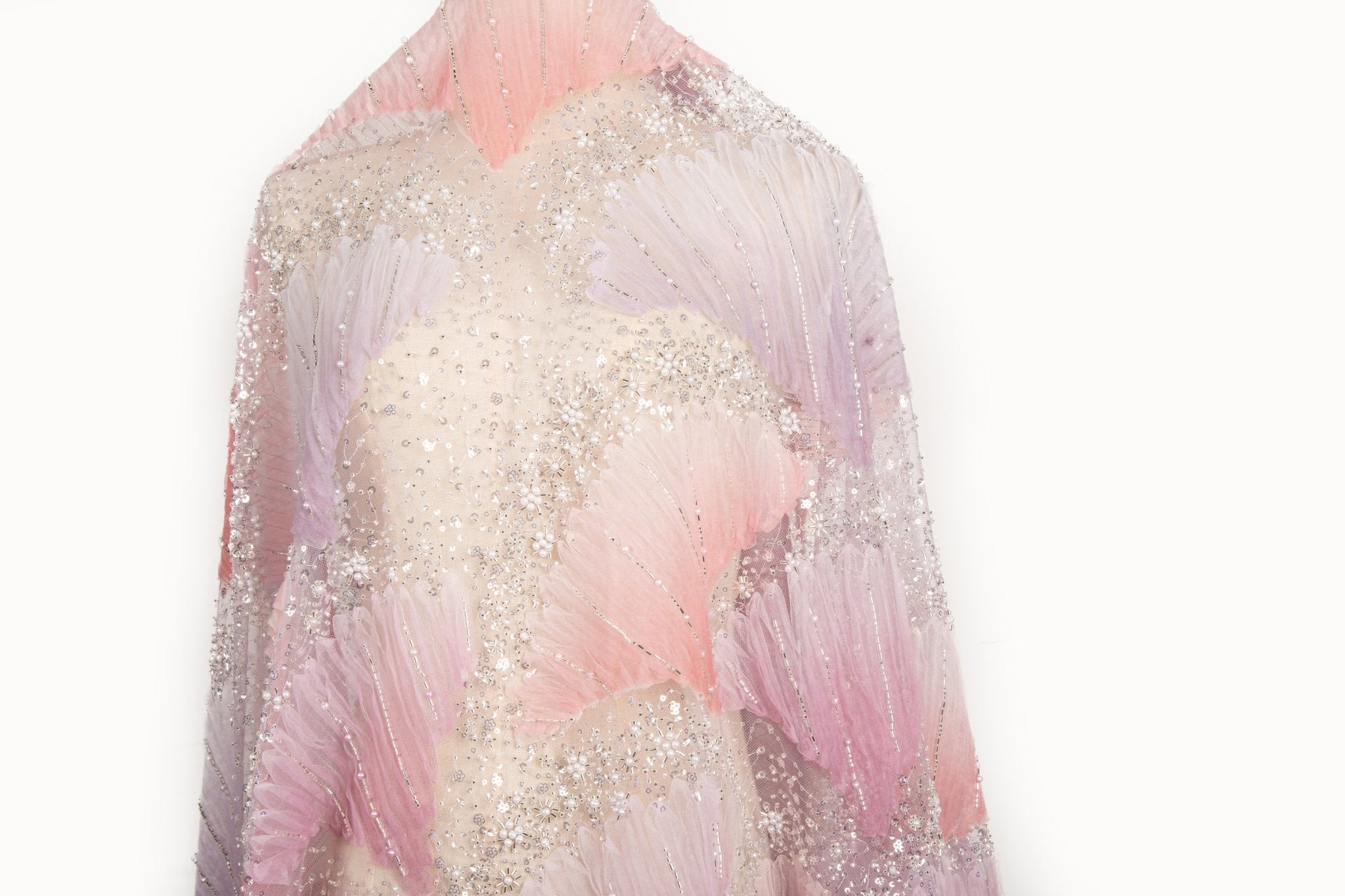 A 3D embroidery fabric with ribbon scallop motifs in a pink and lilac gradient.