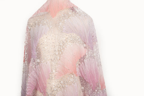 A 3D embroidery fabric with ribbon scallop motifs in a pink and lilac gradient.