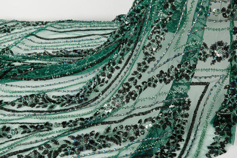 An emerald green Art Deco beaded fabric, with concentric, eye-shaped patterns in black sequins and beads.
