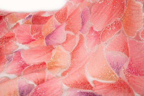 A 3D ribbon and bead embroidery fabric, with feathered petal motifs in a coral and purple gradient.
