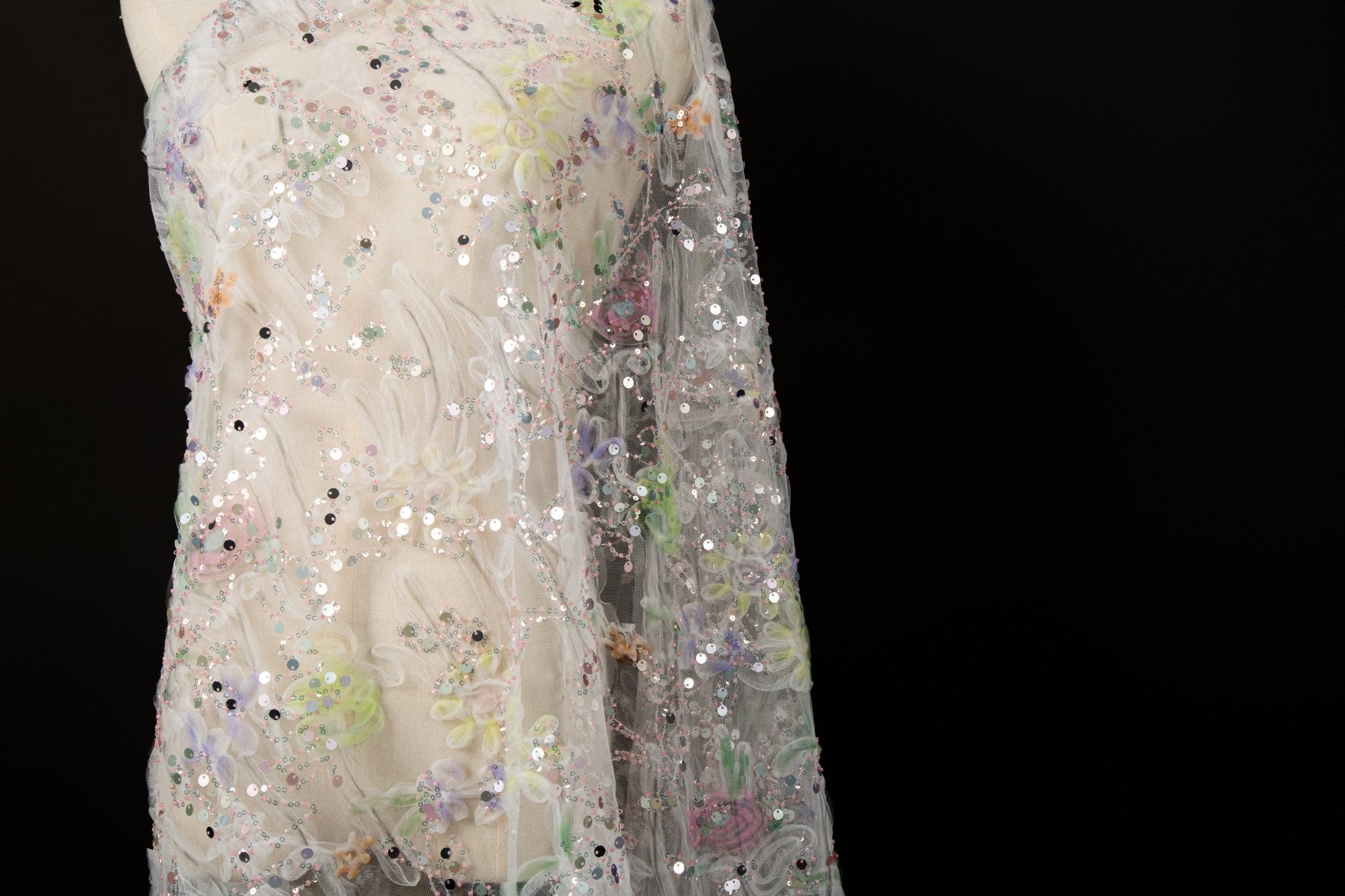 A 3D ruched embroidery fabric with a soft texture, in a palette of mint green, lilac, and pink.
