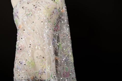 A 3D ruched embroidery fabric with a soft texture, in a palette of mint green, lilac, and pink.
