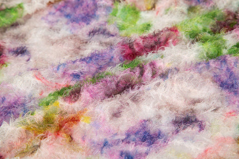 A 3D textured embroidery fabric with a plush feel, in a palette of purple, pink, and green.
