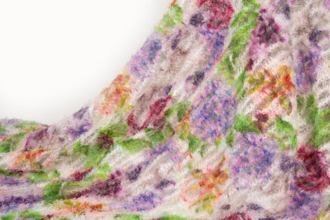 A 3D textured embroidery fabric with a plush feel, in a palette of purple, pink, and green.
