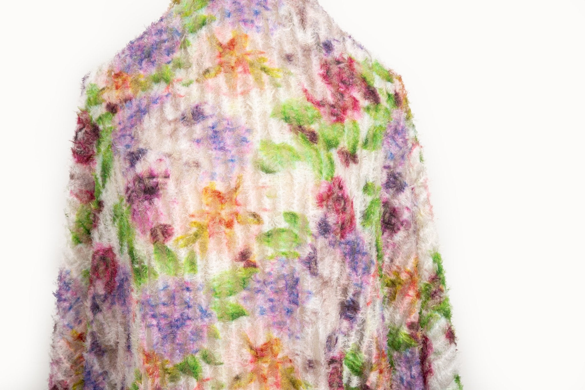 A 3D textured embroidery fabric with a plush feel, in a palette of purple, pink, and green.
