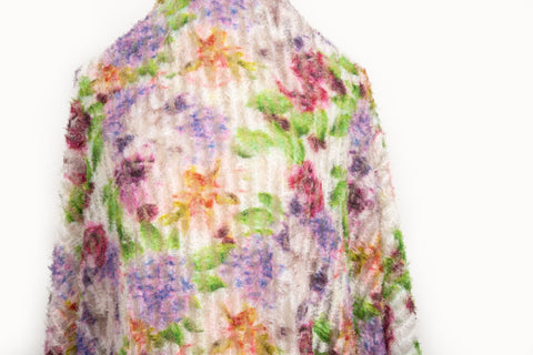 A 3D textured embroidery fabric with a plush feel, in a palette of purple, pink, and green.
