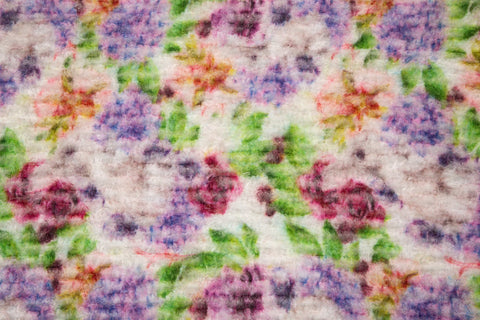 A 3D textured embroidery fabric with a plush feel, in a palette of purple, pink, and green.

