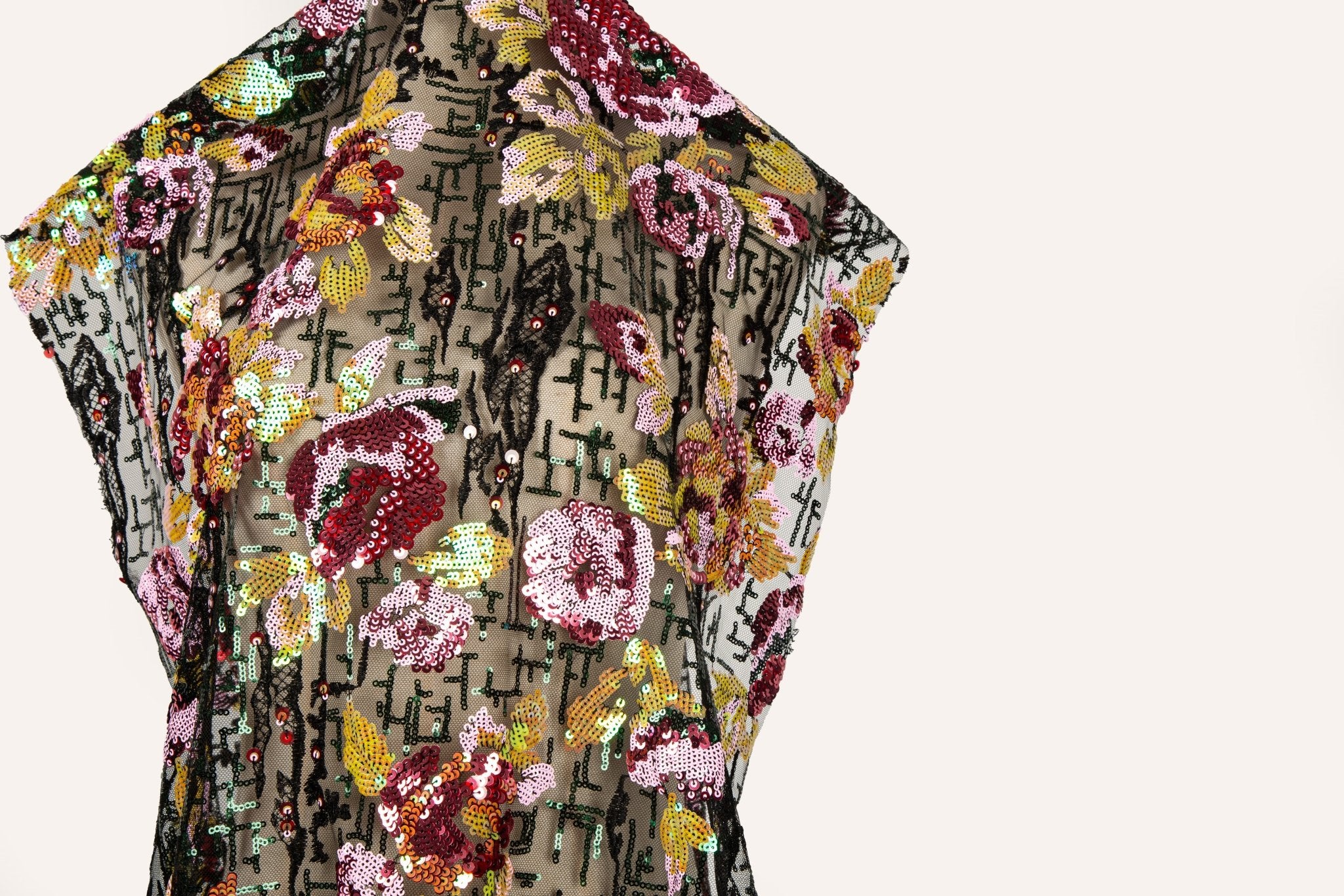 A sequin embroidery fabric on black mesh with burgundy florals over black geometric patterns.
