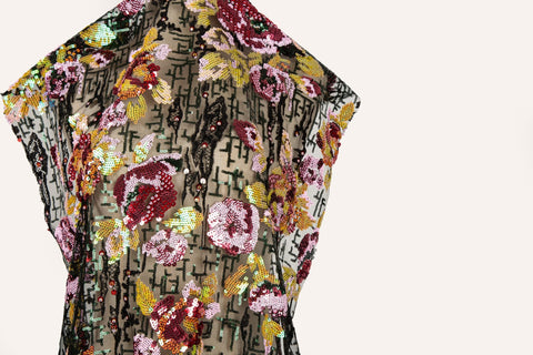 A sequin embroidery fabric on black mesh with burgundy florals over black geometric patterns.
