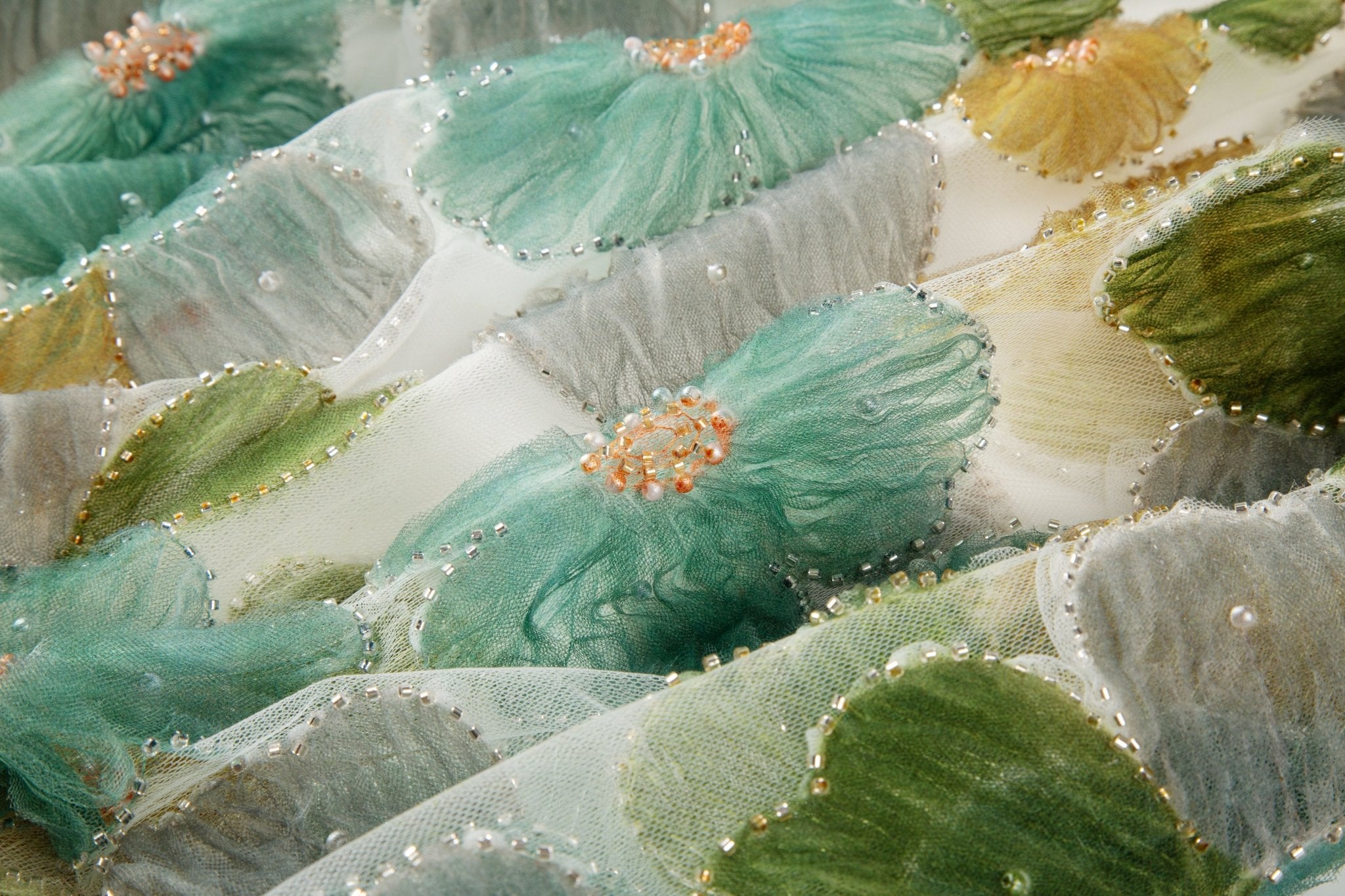 Green, ochre, and grey crinkle ribbon embroidered floral fabric.