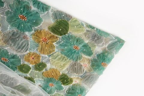 Green, ochre, and grey crinkle ribbon embroidered floral fabric.
