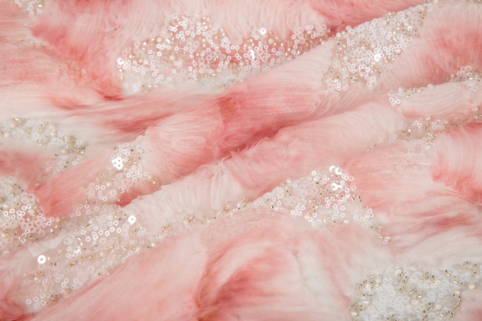 A 3D ribbon and beaded embroidery fabric in light coral.
