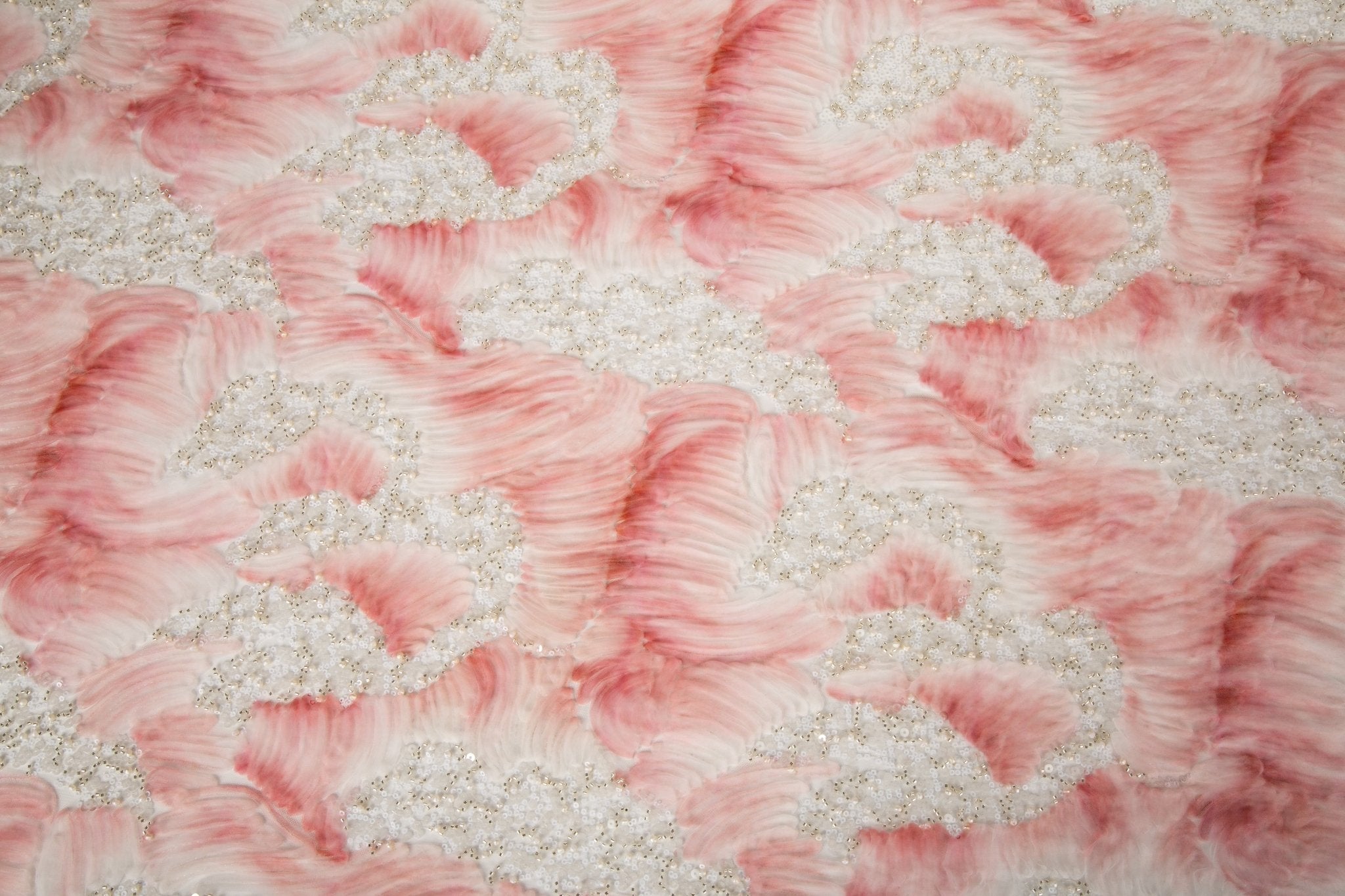 A 3D ribbon and beaded embroidery fabric in light coral.
