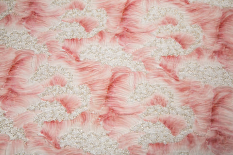 A 3D ribbon and beaded embroidery fabric in light coral.
