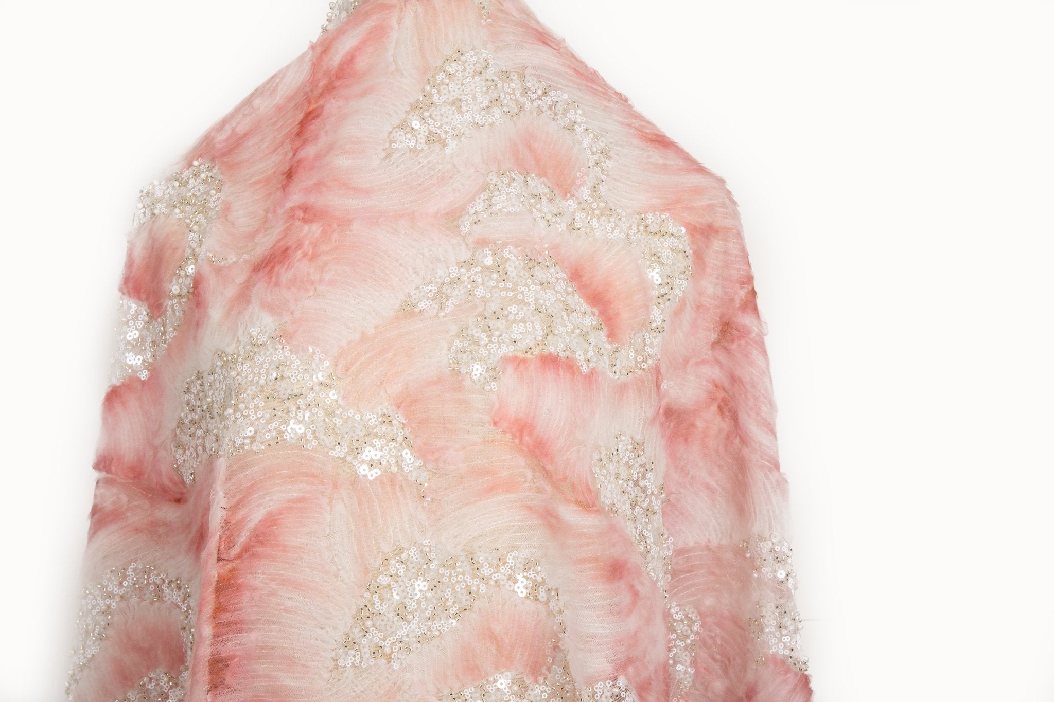 A 3D ribbon and beaded embroidery fabric in light coral.
