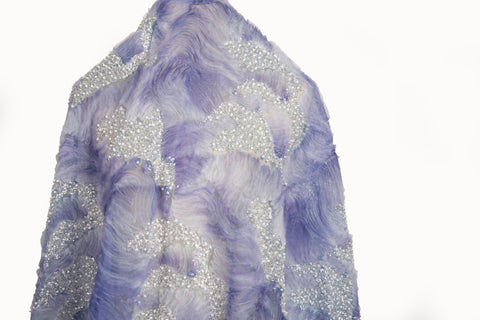 A 3D ribbon and beaded embroidery fabric in lilac purple.
