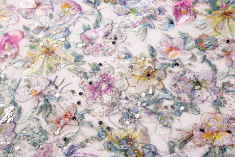  A dense, painterly floral sequin and thread embroidery fabric in a cool palette of purples and blues.
