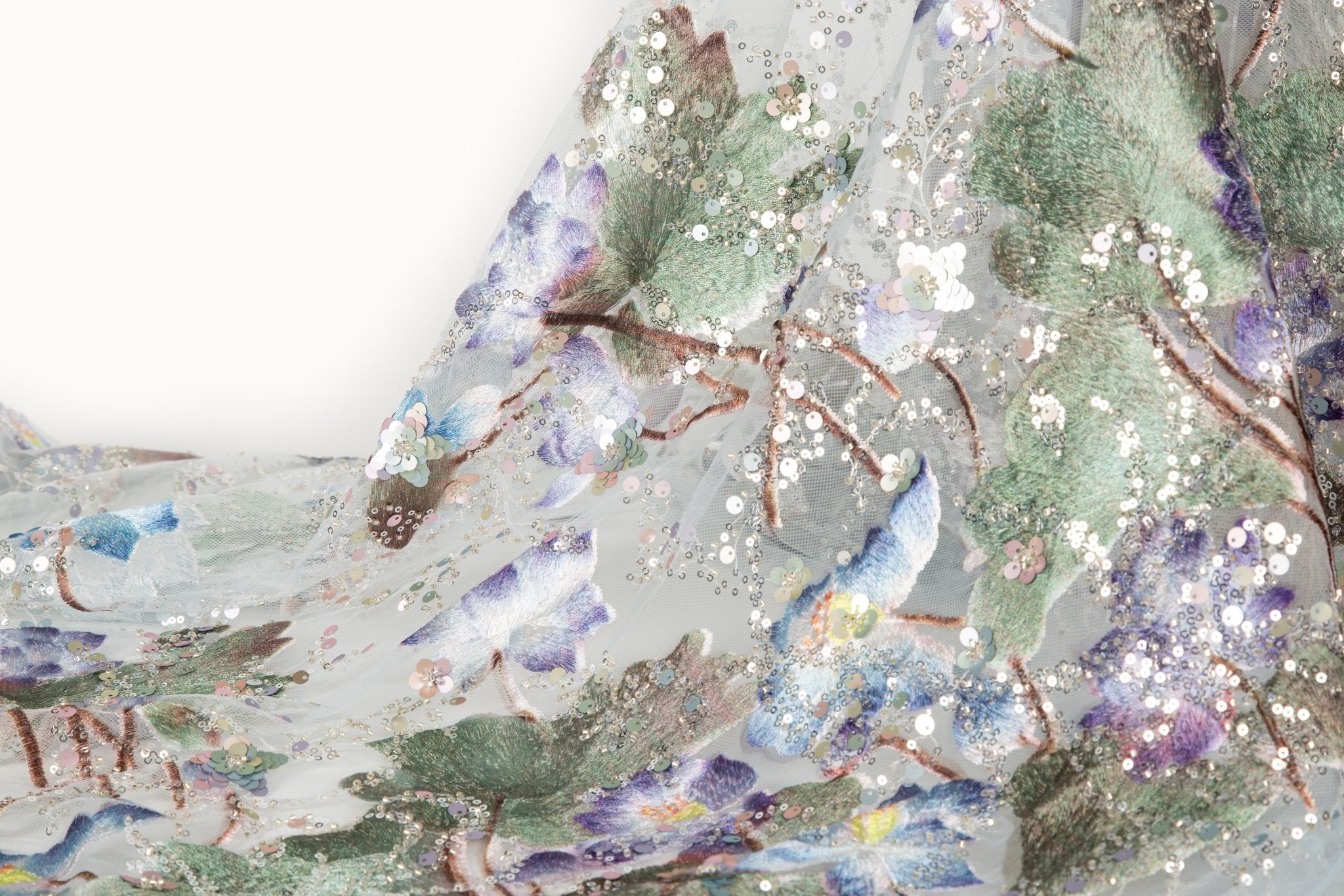 An embroidery fabric on ivory mesh, with a painterly pattern of water lilies in a blue and purple palette.
