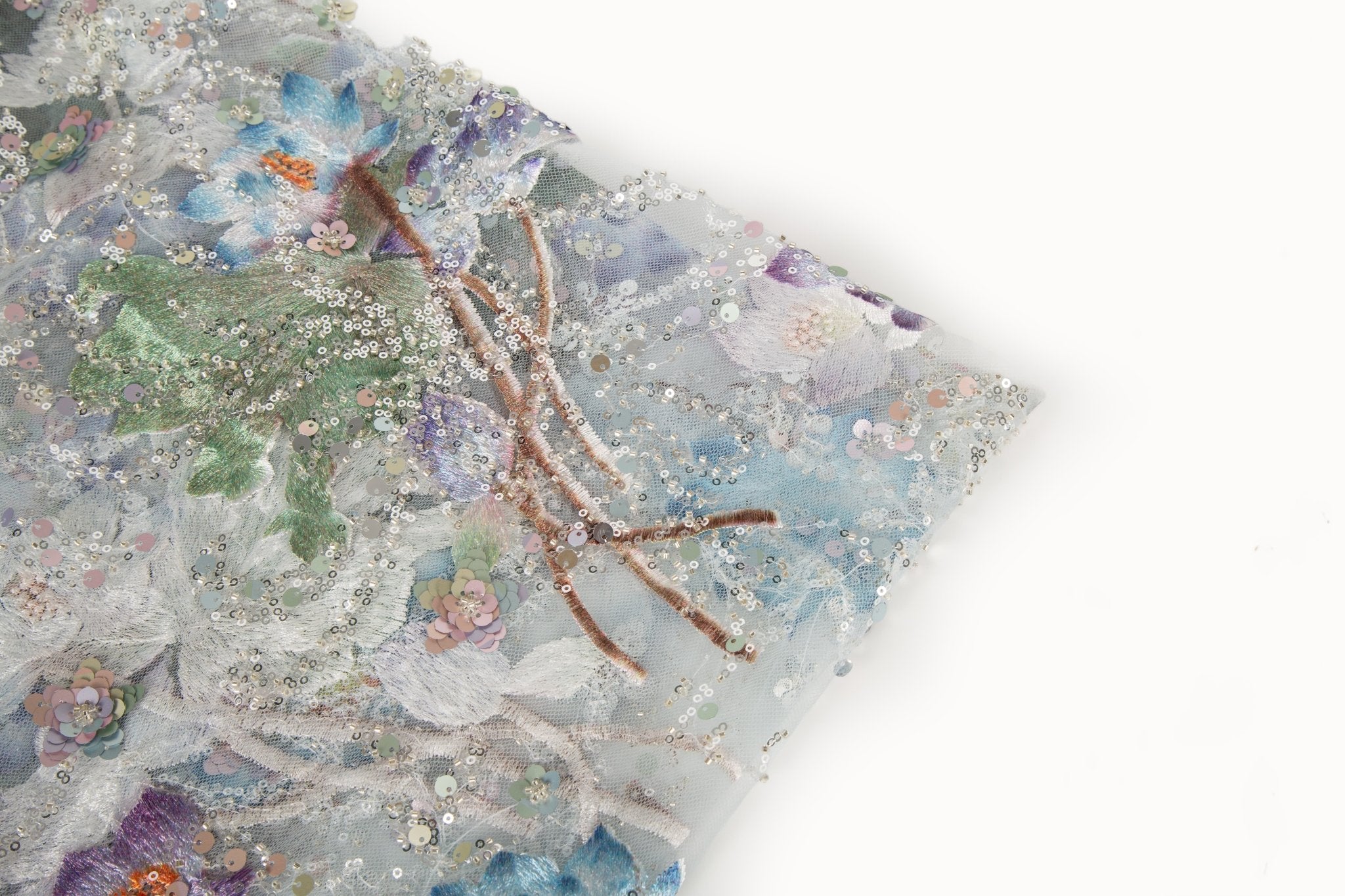 An embroidery fabric on ivory mesh, with a painterly pattern of water lilies in a blue and purple palette.
