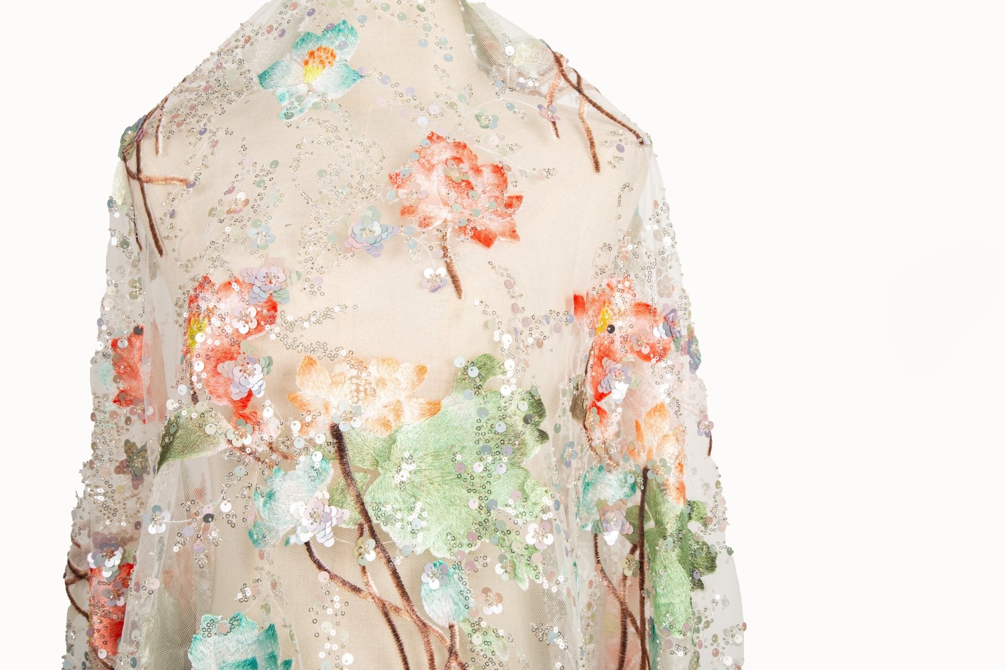 An embroidery fabric on ivory mesh, with a painterly pattern of water lilies in a blue and purple palette.
