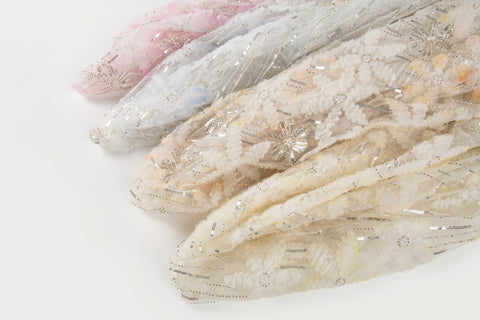 A fabric with 3D textured flowers and sequin embroidery, shown in various pastel color options.