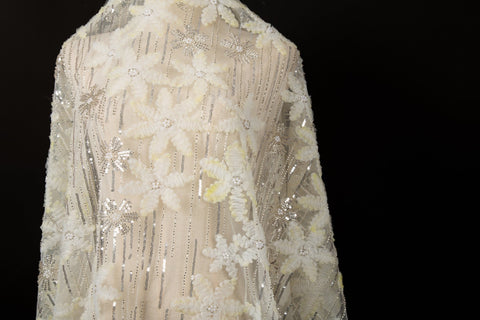 Yellow 3D textured floral and silver sequin embroidery fabric.