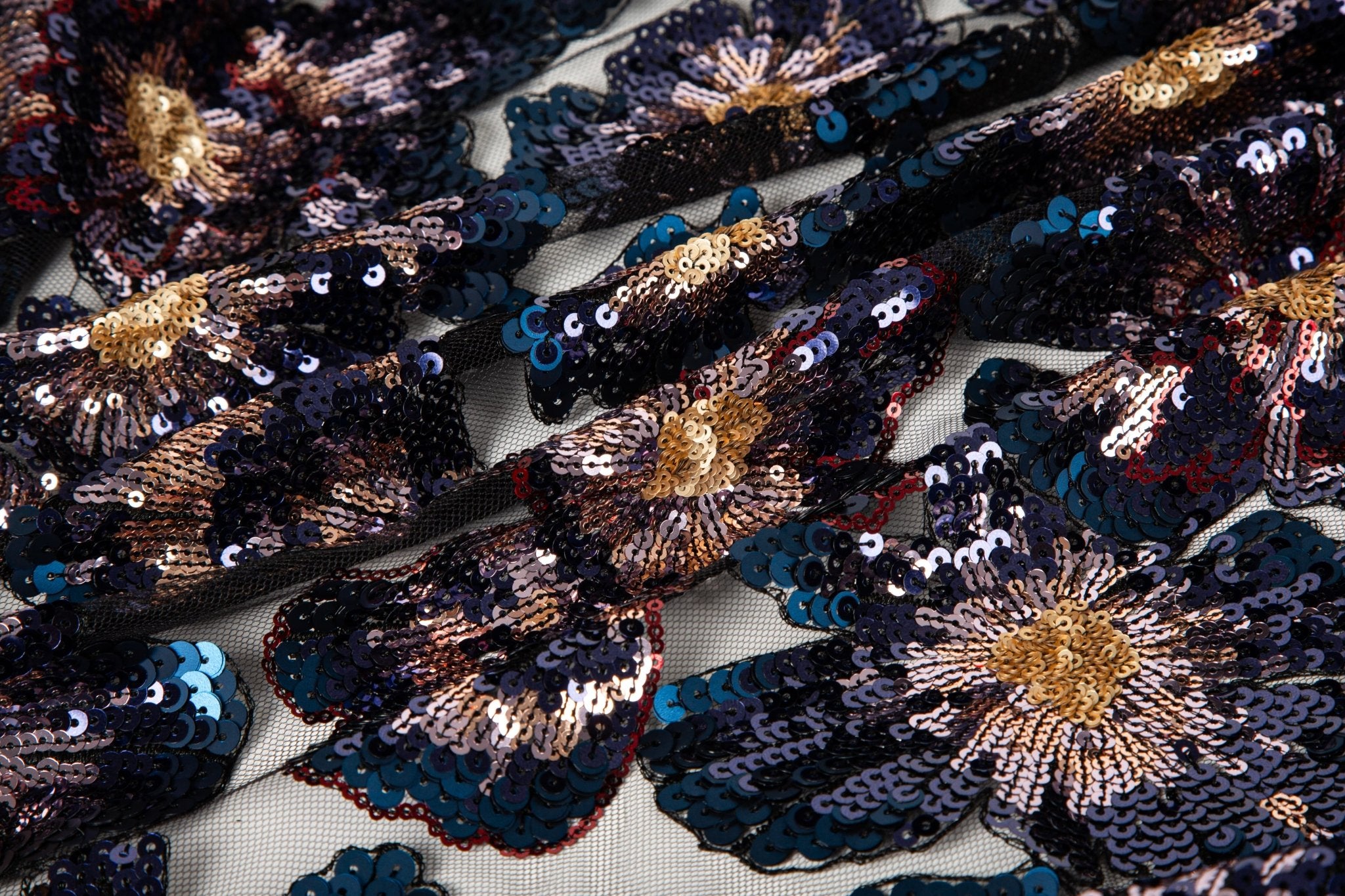 A large floral sequin embroidery fabric on a black base, with blue and gold motifs.
