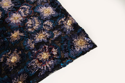 A large floral sequin embroidery fabric on a nude base, with red and pink motifs.
