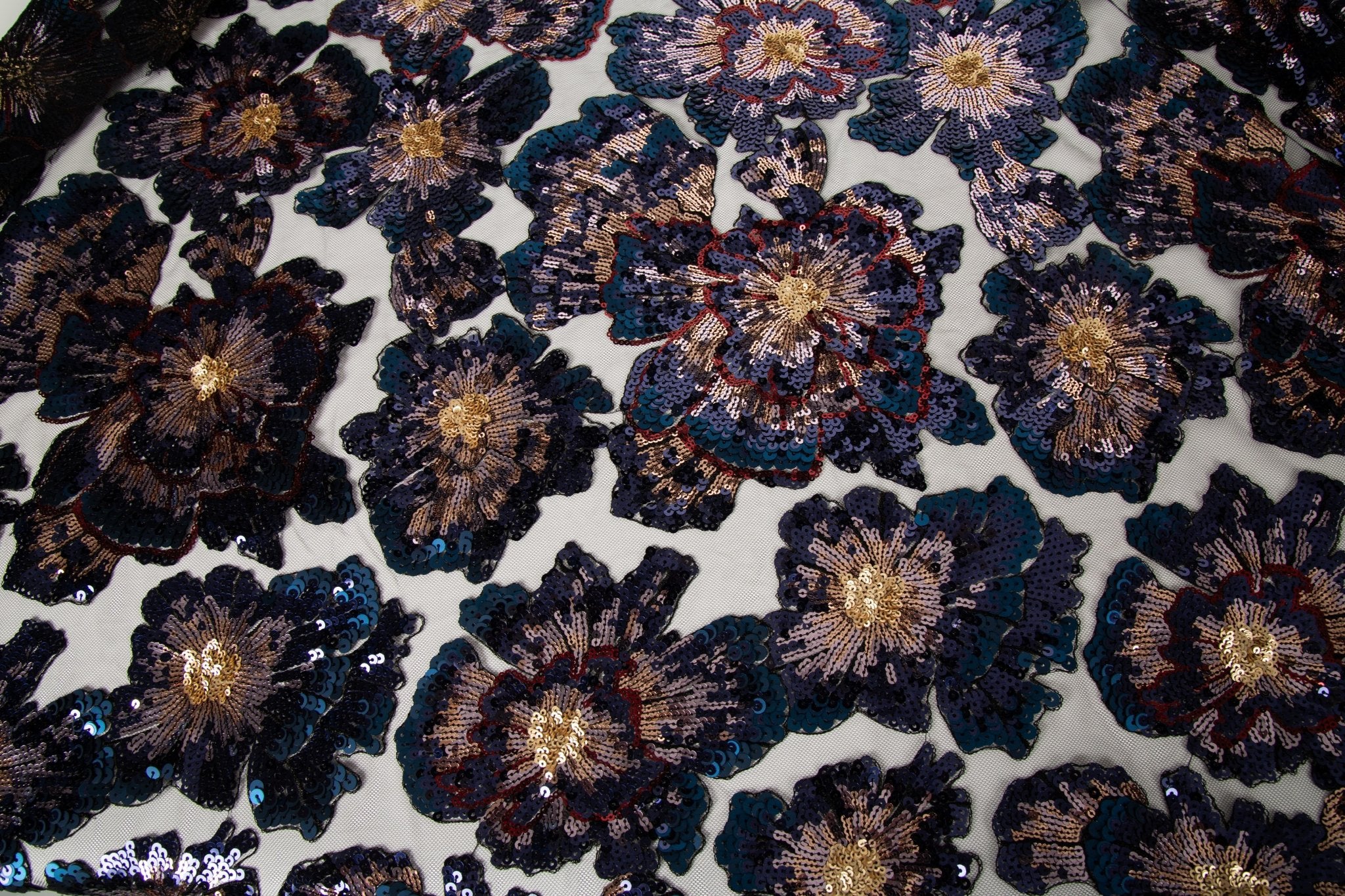 A large floral sequin embroidery fabric on a black base, with blue and gold motifs.
