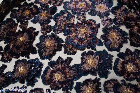 A large floral sequin embroidery fabric on a black base, with blue and gold motifs.
