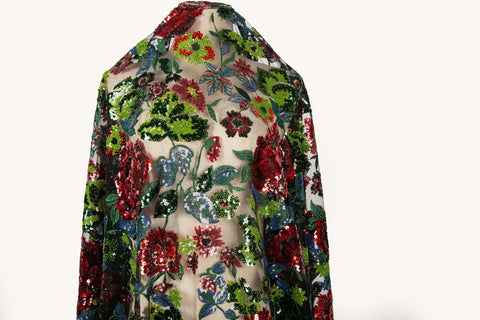 A sequin floral embroidery fabric on a black base, with red and green motifs.