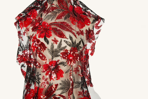 sequin embroidery fabric on a nude base, with red floral and black leaf motifs.