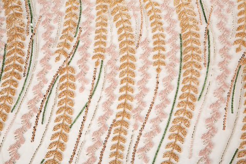 A hand-beaded embroidery fabric, with a vertical, wavy pattern of laurel leaves in rose gold, pink, and green.
