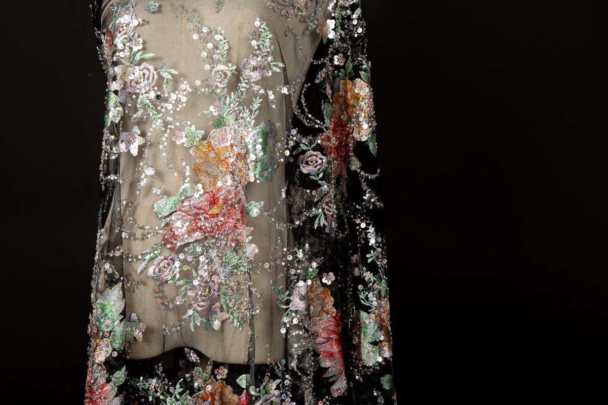 A painterly floral sequin and thread embroidery fabric on a black mesh base with richly colored flowers.

