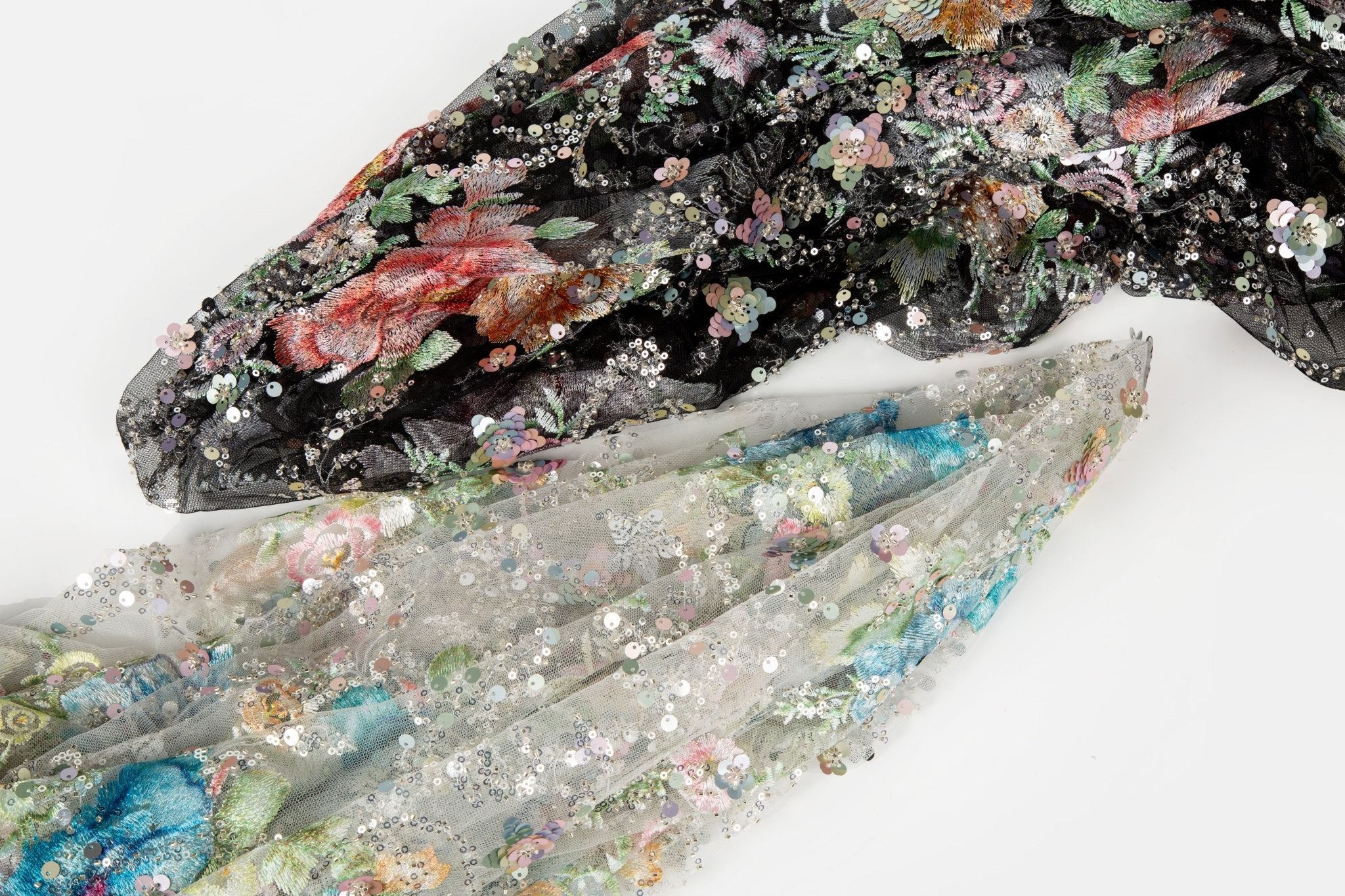    A painterly floral sequin and thread embroidery fabric on a black mesh base with richly colored flowers.
   A painterly floral sequin and thread embroidery fabric on an ivory mesh base with soft pastel-colored flowers.

