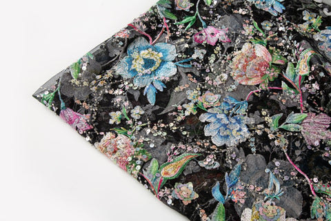 A multi-color floral sequin embroidery fabric on a black mesh base.
