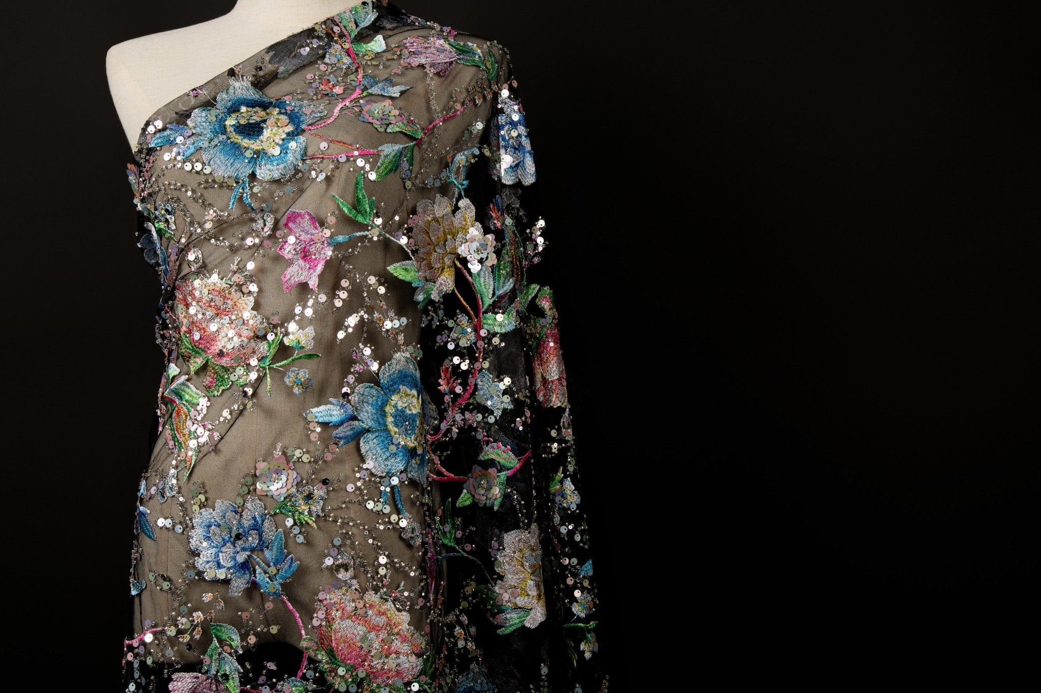 A multi-color floral sequin embroidery fabric on a black mesh base.
