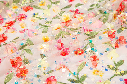 A 3D embroidery fabric with a multi-color wildflower pattern, embellished with sequins and beads.
