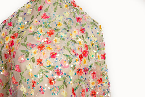 A 3D embroidery fabric with a multi-color wildflower pattern, embellished with sequins and beads.
